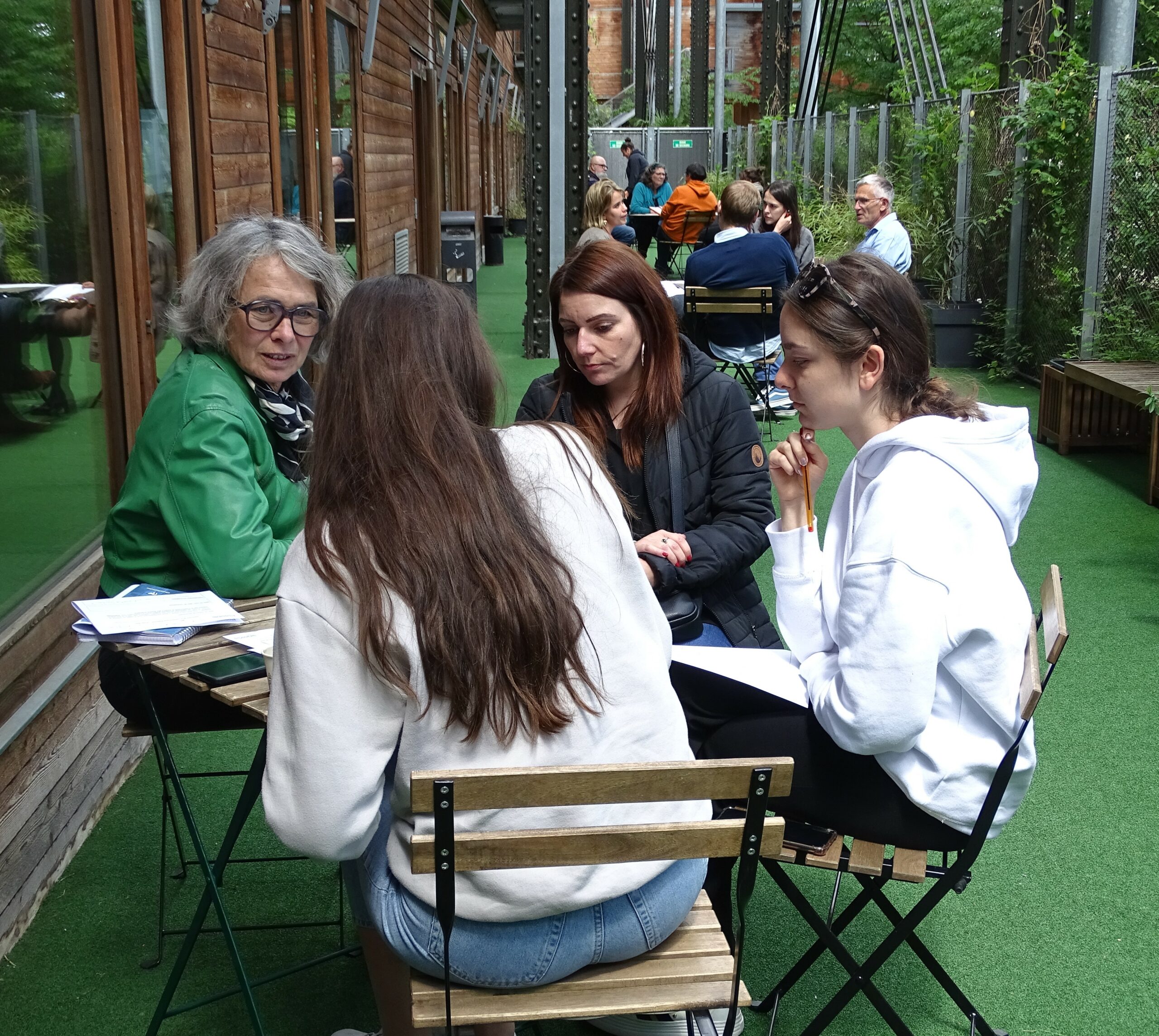 4 membres de la communauté possible réunis autour d'une table échangent